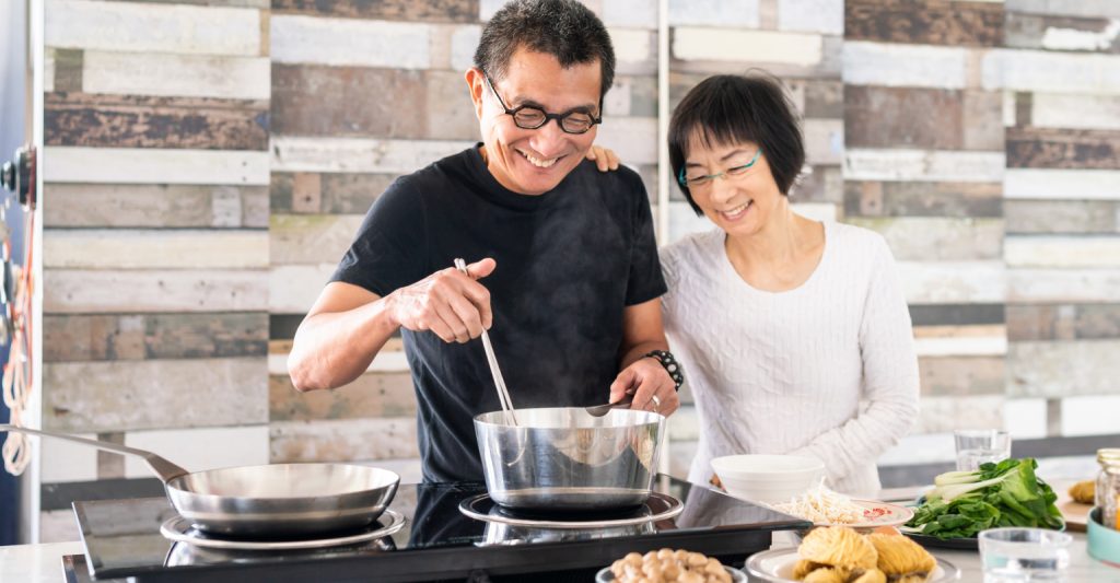A chef skillfully cooks noodles in a wok on a stove, creating a delicious and aromatic dish